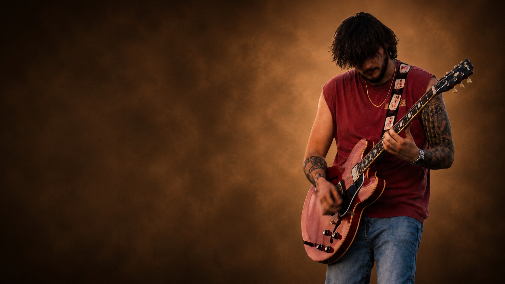 Anthony Segovia playing guitar beneath a warm, smoky spotlight